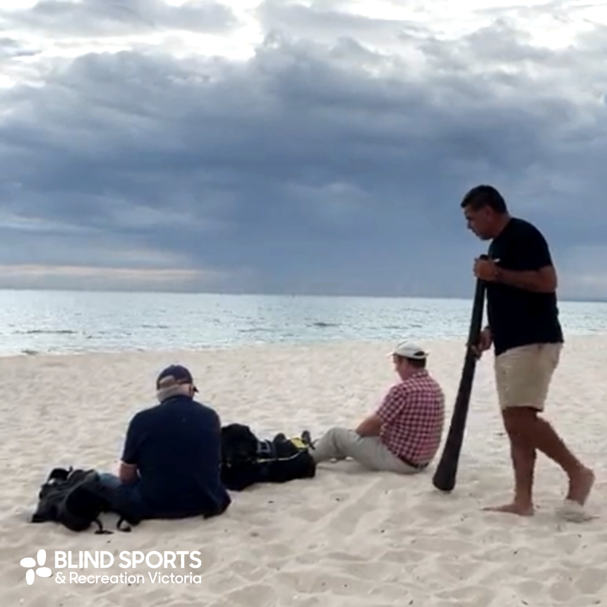 Lionel playing the Yidaki (digeridoo) on the beach.